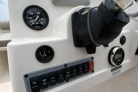 Slide: The Image of 2024 Key West 203 DFS boat dashboard with gauges and control switches. - 11