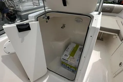 Slide: The Image of 2024 Key West 203 DFS boat storage compartment with open door and packaged item inside. - 12