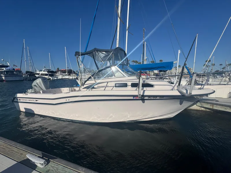 The Image of 1996 Grady-White Voyager 248 boat docked in marina under clear blue sky. - 0