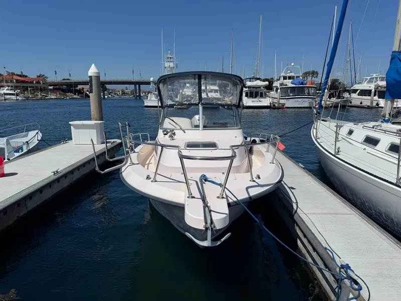 Slide: The Image of 1996 Grady-White Voyager 248 docked in a marina, surrounded by other boats. - 2