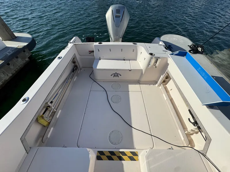 Slide: The Image of 1996 Grady-White Voyager 248 boat deck, clean and spacious, docked by the water. - 4