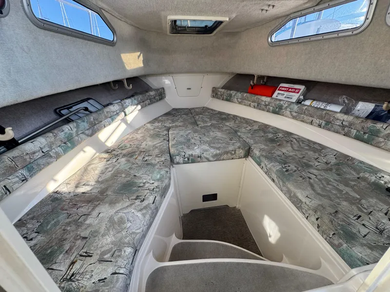 Slide: The Image of 1996 Grady-White Voyager 248 cabin interior with patterned cushions and storage compartments. - 9