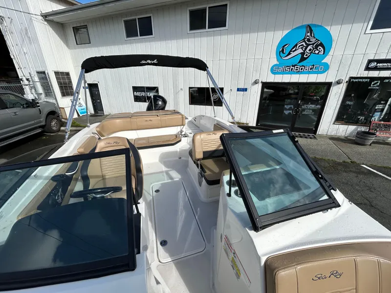 Slide: The Image of 2021 Sea Ray SPX 210 OB boat with tan seating, docked near a marine shop. - 10