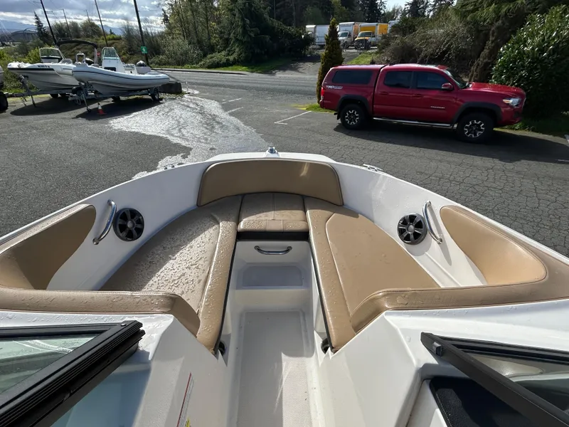 Slide: The Image of 2021 Sea Ray SPX 210 OB boat with tan seating, parked near a red truck. - 14