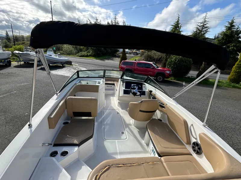 Slide: The Image of 2021 Sea Ray SPX 210 OB boat with beige seating and black canopy, parked outdoors. - 9