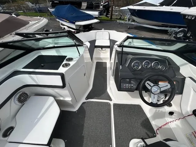 Slide: The Image of Interior view of a 2015 Sea Ray 21 SPX boat, featuring steering wheel and seating. - 10