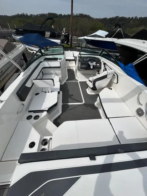 Slide: The Image of 2015 Sea Ray 21 SPX boat interior with seating and steering wheel, docked outdoors. - 8