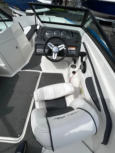 Slide: The Image of Interior view of 2015 Sea Ray 21 SPX boat, featuring steering wheel and dashboard. - 9