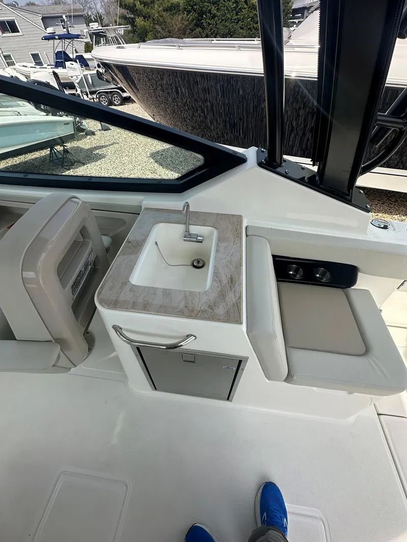 Slide: The Image of 2025 Boston Whaler 280 Vantage boat interior with sink and seating area. - 13