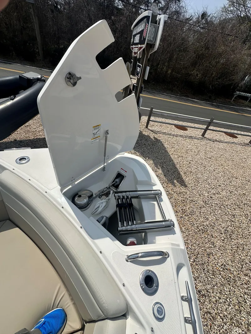 Slide: The Image of 2025 Boston Whaler 280 Vantage boat storage compartment with open lid, showcasing interior features. - 27