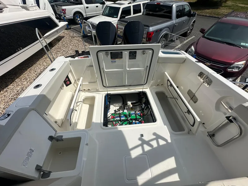 Slide: The Image of 2025 Boston Whaler 280 Vantage boat interior with open storage compartments and visible engine components. - 6