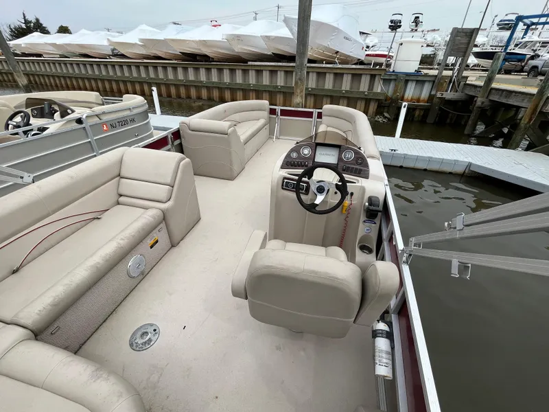 Slide: The Image of Pontoon boat interior with beige seating, Avalon CATALINA 22, 2014 model, docked at marina. - 11