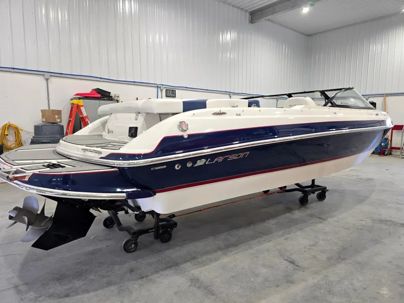 Slide: The Image of 2019 Larson LX 225 IO boat in a spacious indoor storage facility. - 0