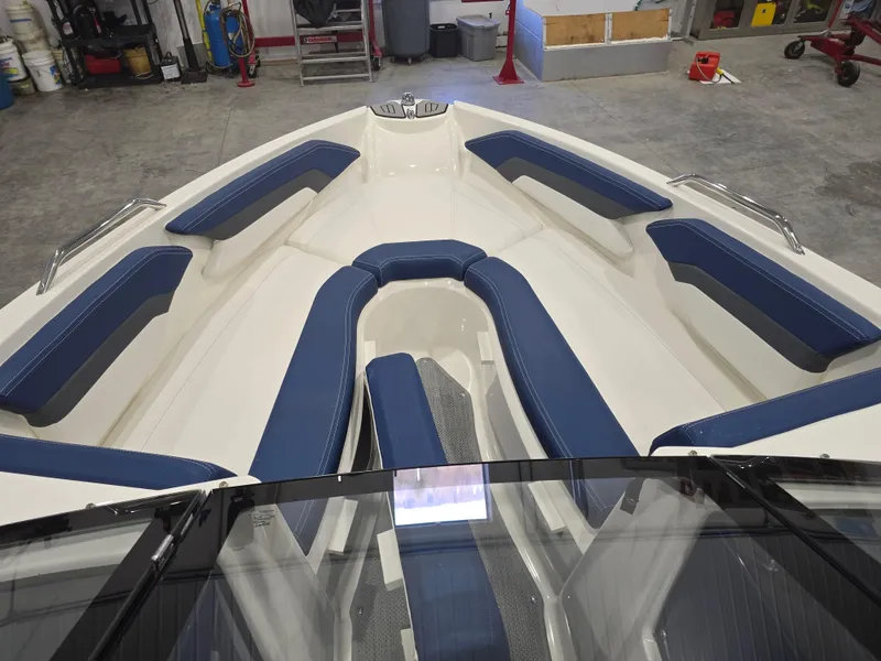 Slide: The Image of 2019 Larson LX 225 IO boat interior with blue seating in a garage setting. - 1