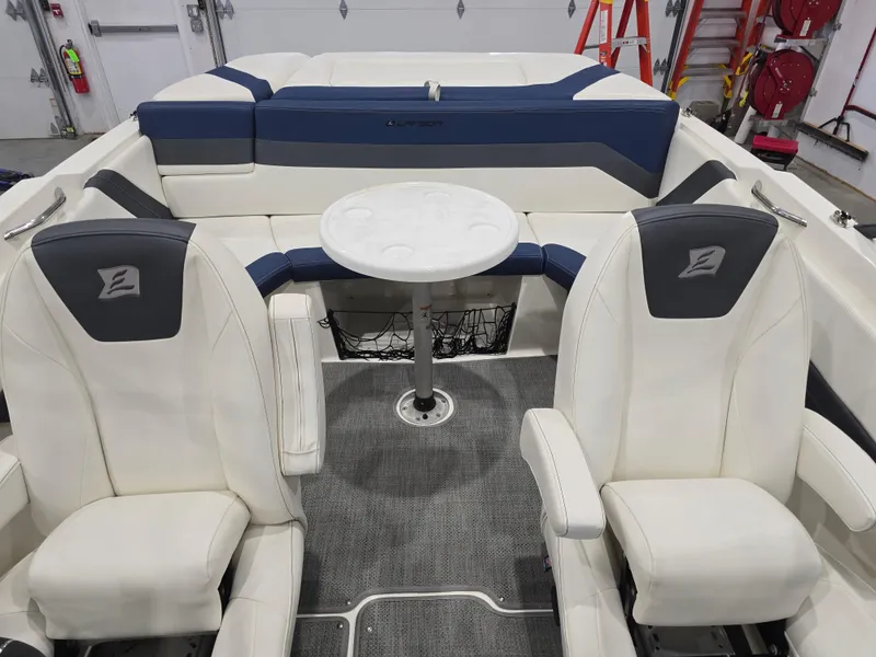 Slide: The Image of 2019 Larson LX 225 IO boat interior with white seating and a central table. - 11