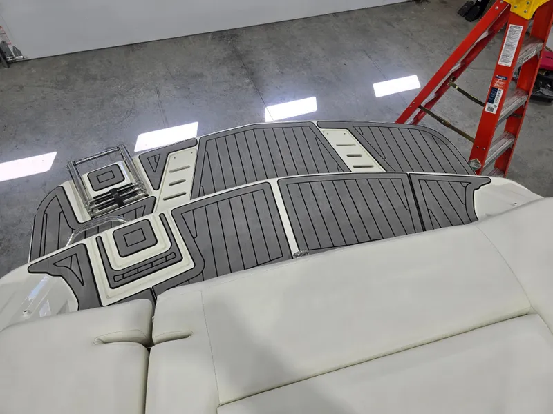 Slide: The Image of 2019 Larson LX 225 IO boat interior with custom flooring and white seating. - 12