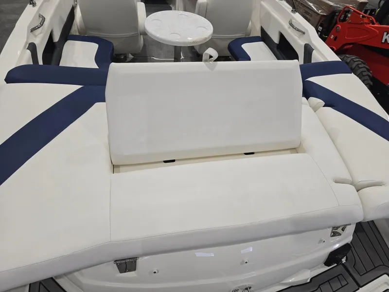 Slide: The Image of 2019 Larson LX 225 IO boat interior with white and blue seating and a round table. - 13