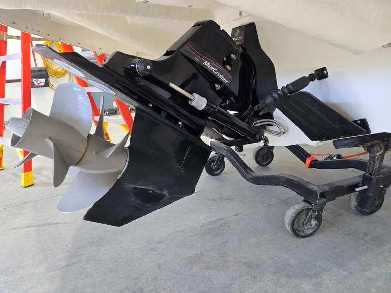 Slide: The Image of 2019 Larson LX 225 IO boat with visible propeller and outdrive on a trailer. - 15