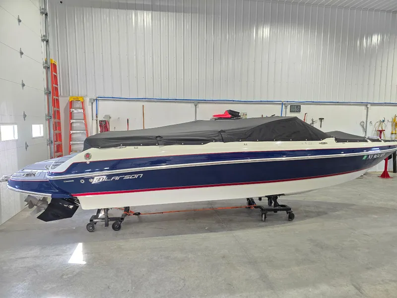Slide: The Image of 2019 Larson LX 225 IO boat in storage, covered, inside a spacious garage. - 17