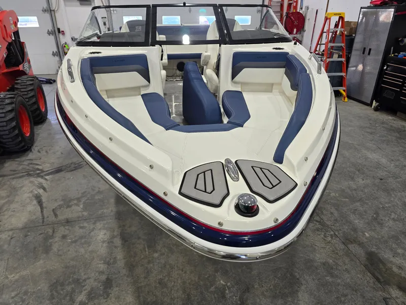 Slide: The Image of 2019 Larson LX 225 IO boat with blue and white interior in a garage setting. - 23
