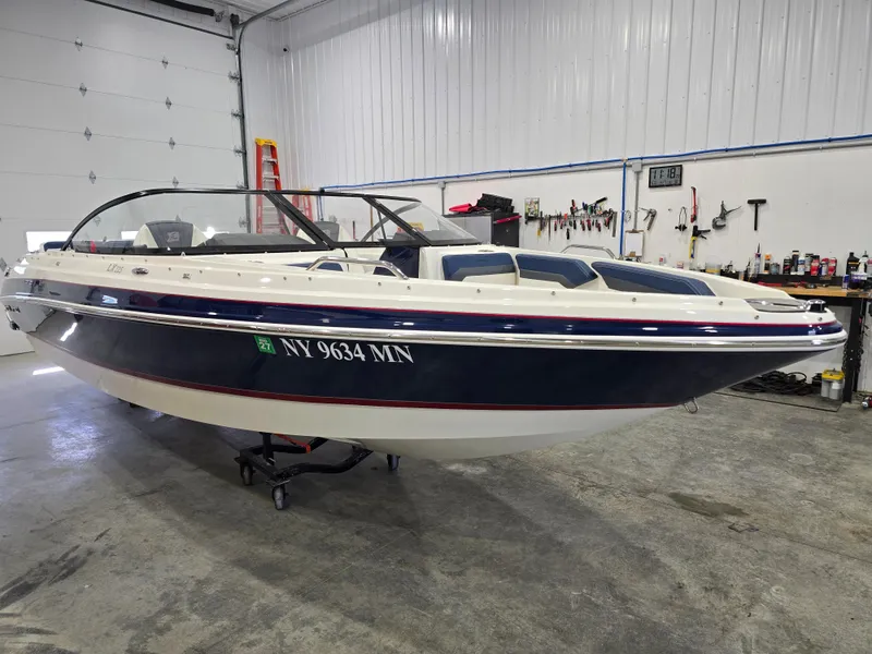 Slide: The Image of 2019 Larson LX 225 IO boat in a garage, blue and white exterior, registration NY 9634 MN. - 24