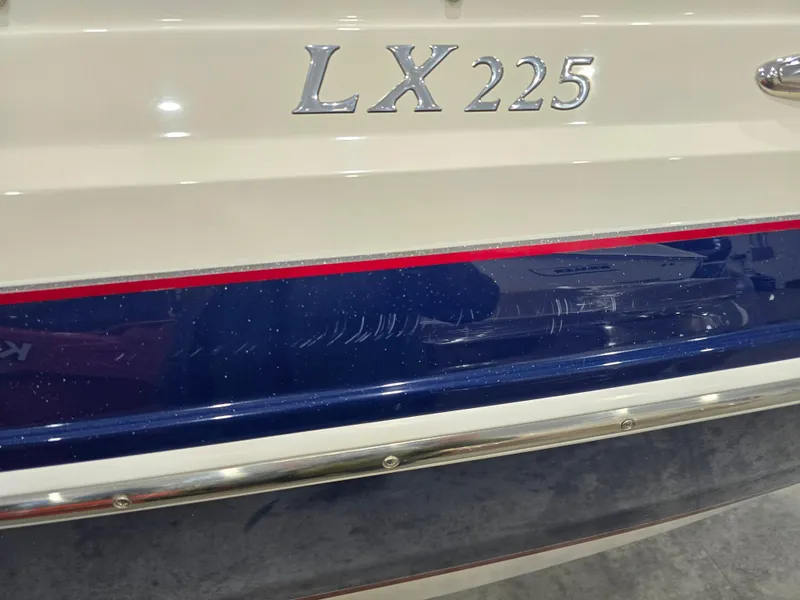 Slide: The Image of 2019 Larson LX 225 IO boat with sleek design and blue accent stripe. - 26