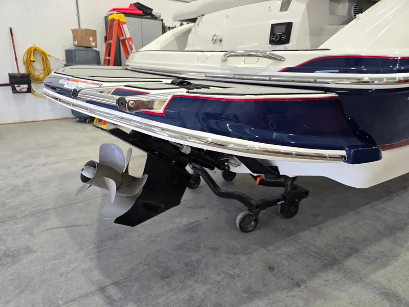Slide: The Image of 2019 Larson LX 225 IO boat in garage, showing rear view with propeller. - 27