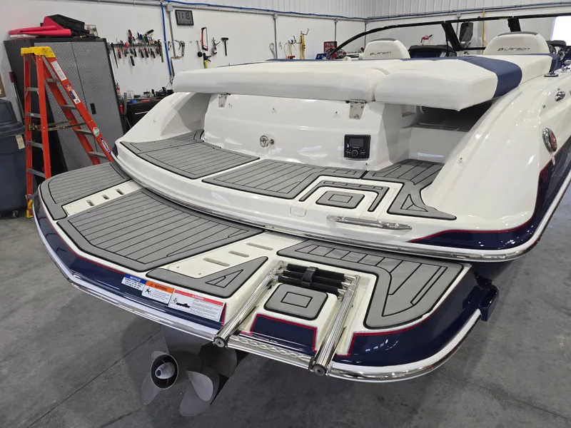 Slide: The Image of 2019 Larson LX 225 IO boat with swim platform in a workshop setting. - 28