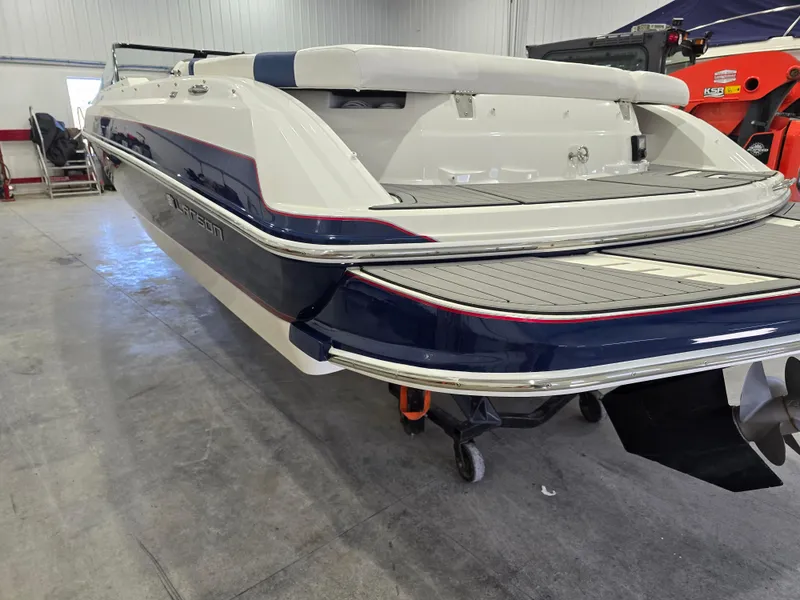 Slide: The Image of 2019 Larson LX 225 IO boat in a garage, showcasing sleek design and modern features. - 29