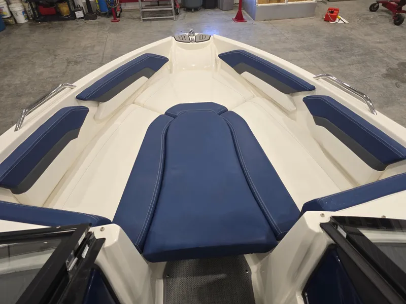 Slide: The Image of 2019 Larson LX 225 IO boat interior with blue and white seating in a garage setting. - 3