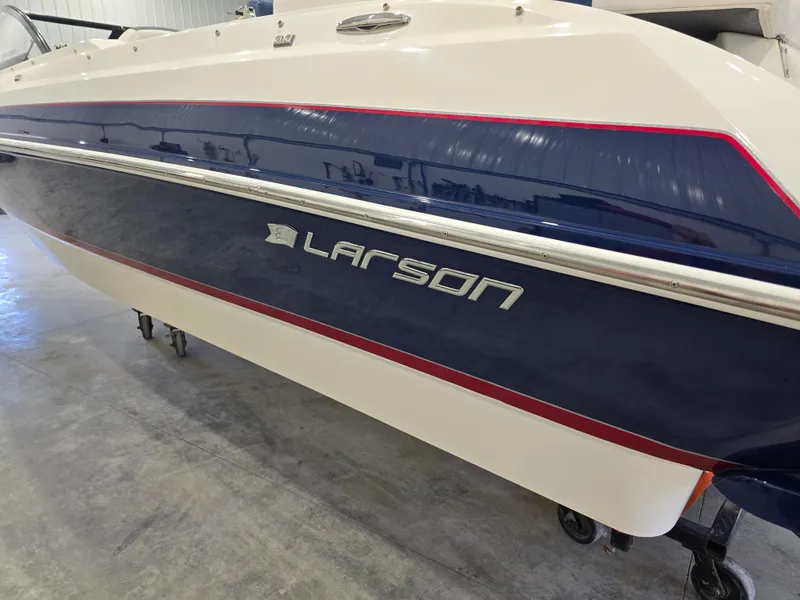 Slide: The Image of 2019 Larson LX 225 IO boat with blue and white exterior, displayed indoors. - 30