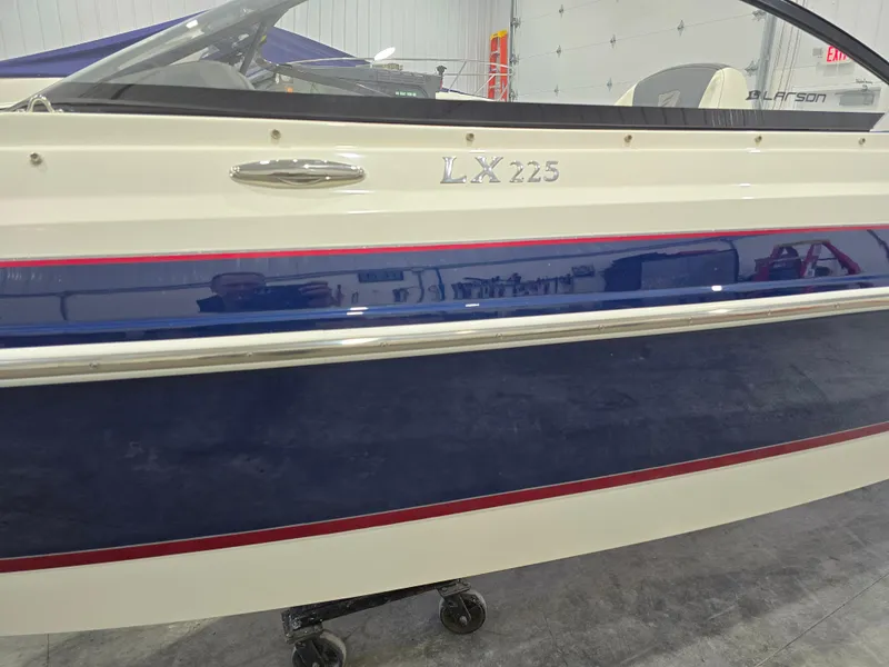 Slide: The Image of 2019 Larson LX 225 IO boat side view with blue and red accents. - 31