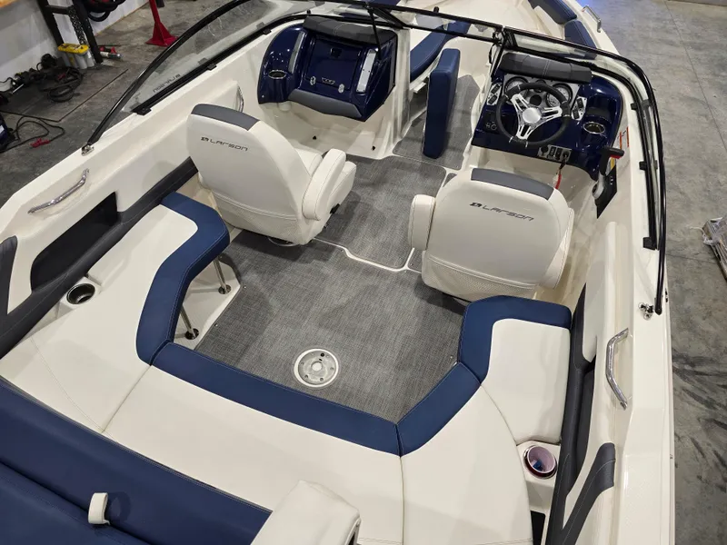 Slide: The Image of 2019 Larson LX 225 IO boat interior with blue and white seating and modern dashboard. - 33