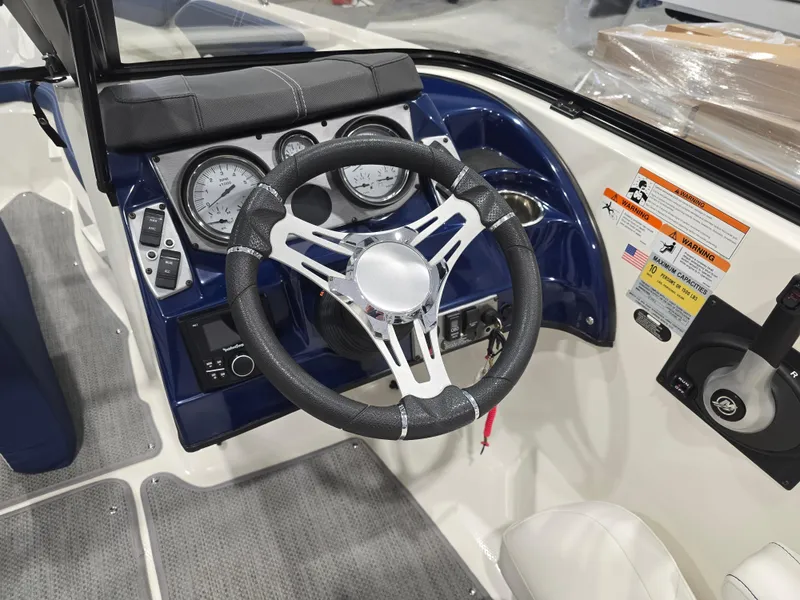 Slide: The Image of Steering wheel and dashboard of 2019 Larson LX 225 IO boat, featuring gauges and controls. - 36