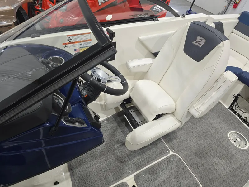 Slide: The Image of Interior of a 2019 Larson LX 225 IO boat with white captain's chair and steering wheel. - 5