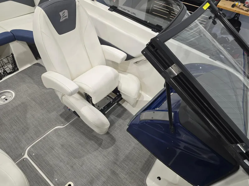 Slide: The Image of 2019 Larson LX 225 IO boat interior with white captain's chair and gray carpet. - 6