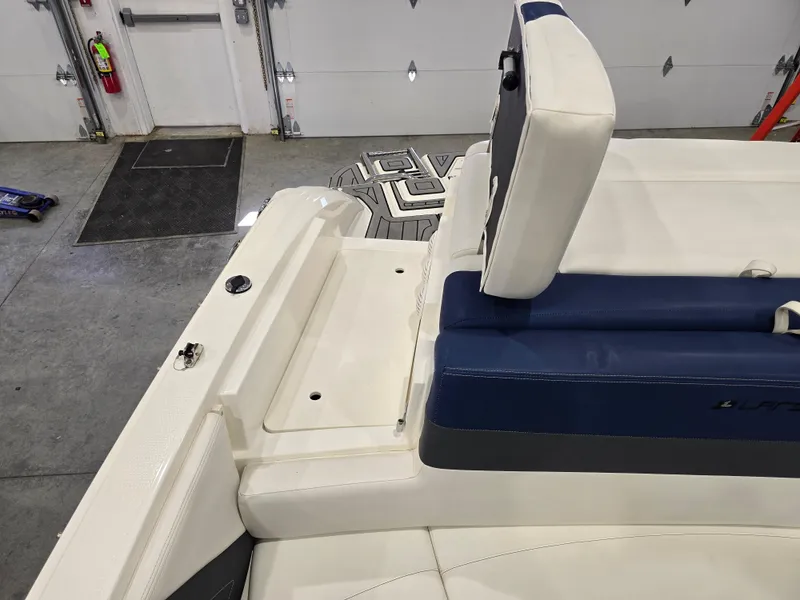 Slide: The Image of 2019 Larson LX 225 IO boat interior with blue and white seating in a garage setting. - 9