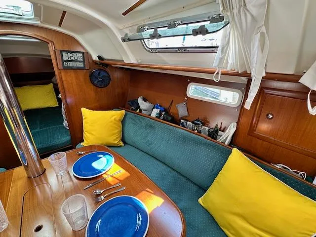 Slide: The Image of Interior of 2000 Beneteau Oceanis 311 sailboat with cozy seating and dining area. - 14