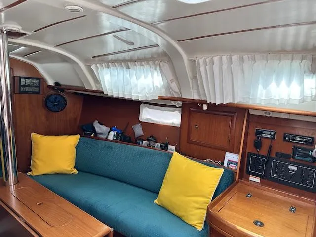 Slide: The Image of Cozy interior of 2000 Beneteau Oceanis 311 sailboat with blue sofa and yellow cushions. - 18
