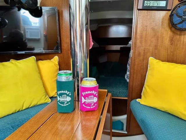 Slide: The Image of Interior of 2000 Beneteau Oceanis 311 sailboat with colorful cushions and drinks on table. - 22