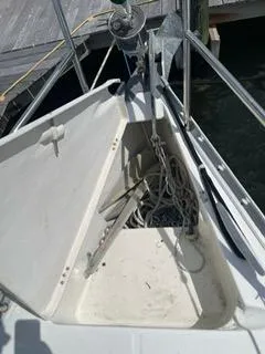 Slide: The Image of Beneteau Oceanis 311 (2000) anchor locker with ropes and anchor, docked at a marina. - 25