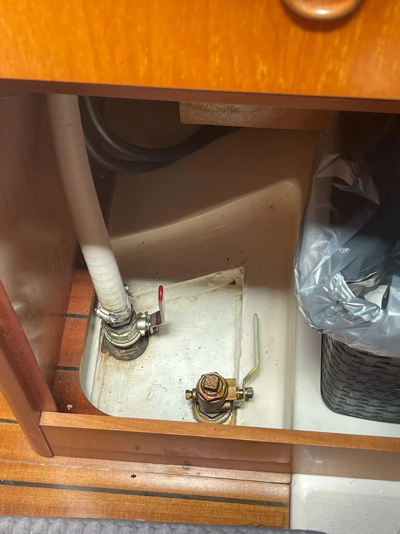 Slide: The Image of Beneteau Oceanis 311 (2000) interior plumbing and storage area with visible pipes and fittings. - 33