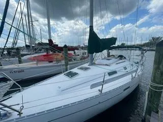 Slide: The Image of 2000 Beneteau Oceanis 311 sailboat docked at marina under cloudy sky. - 36