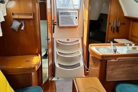 Slide: The Image of Interior of 2000 Beneteau Oceanis 311 sailboat with wood finish and compact kitchen area. - 46