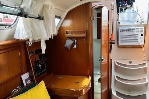 Slide: The Image of Interior of 2000 Beneteau Oceanis 311 sailboat with wood finish and compact amenities. - 48