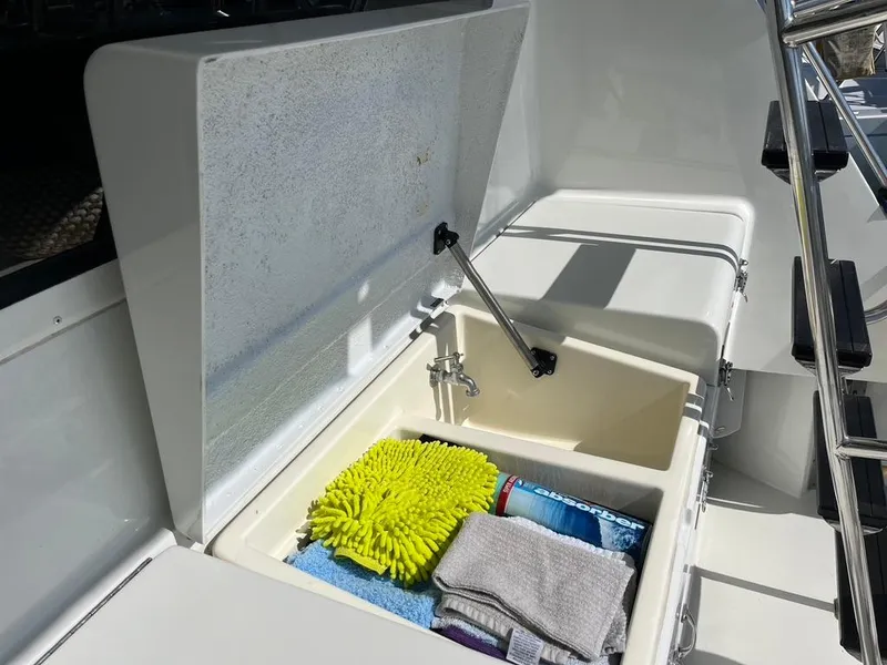 Slide: The Image of Open storage compartment on 1988 Hatteras 52 Convertible boat with cleaning supplies. - 13