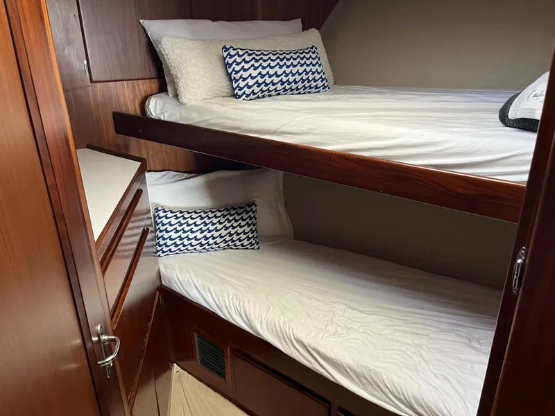 Slide: The Image of Bunk beds in 1988 Hatteras 52 Convertible yacht cabin with wood paneling and decorative pillows. - 15