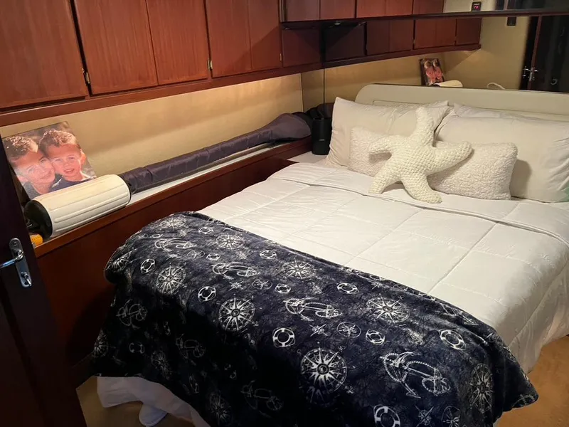 Slide: The Image of Cozy bedroom in 1988 Hatteras 52 Convertible yacht with nautical decor and plush bedding. - 20