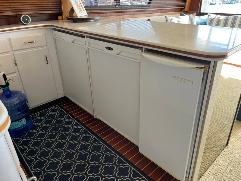 Slide: The Image of Kitchen area of 1988 Hatteras 52 Convertible yacht with white cabinets and countertop. - 25
