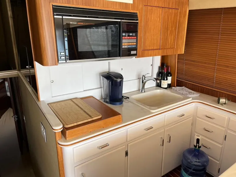 Slide: The Image of Galley kitchen in 1988 Hatteras 52 Convertible yacht with microwave, sink, and wooden cabinetry. - 27